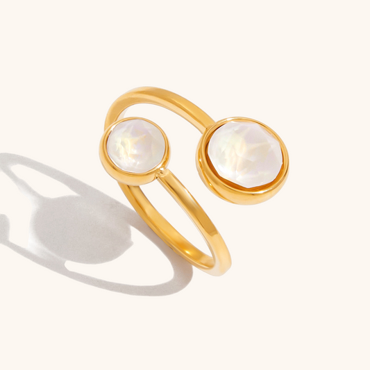 Gold adjustable open ring with two white faceted crystals on light background