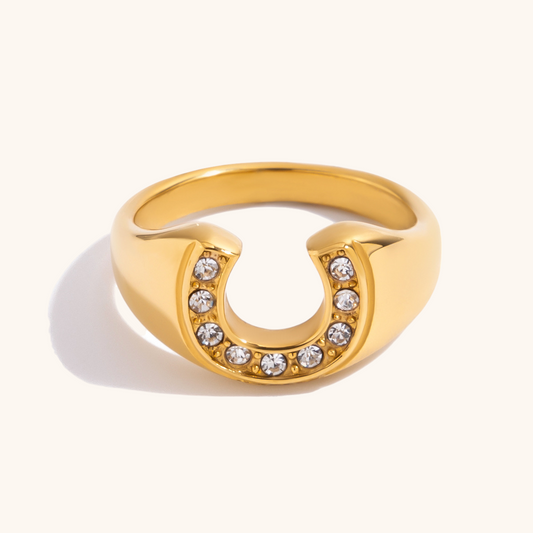 Close-up image of the gold horseshoe ring with embedded white crystals