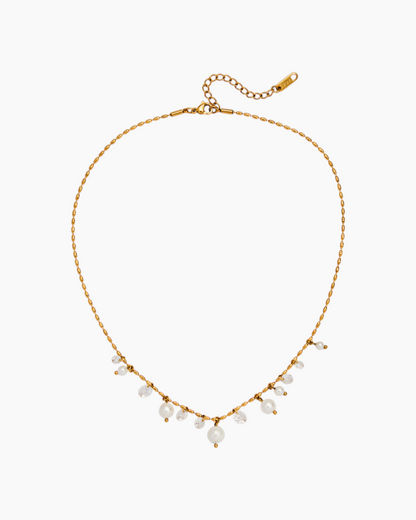 Gold necklace with small pearls on a white background