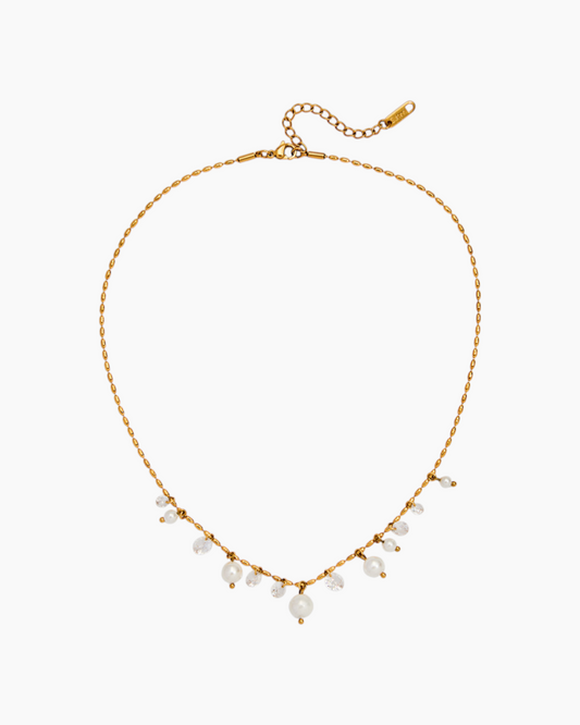 Gold necklace with small pearls on a white background
