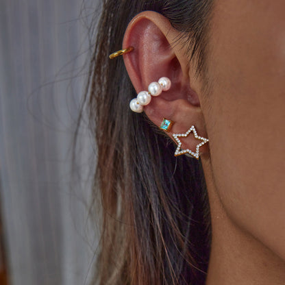 Model wearing star and pearl stud earrings in layered ear styling