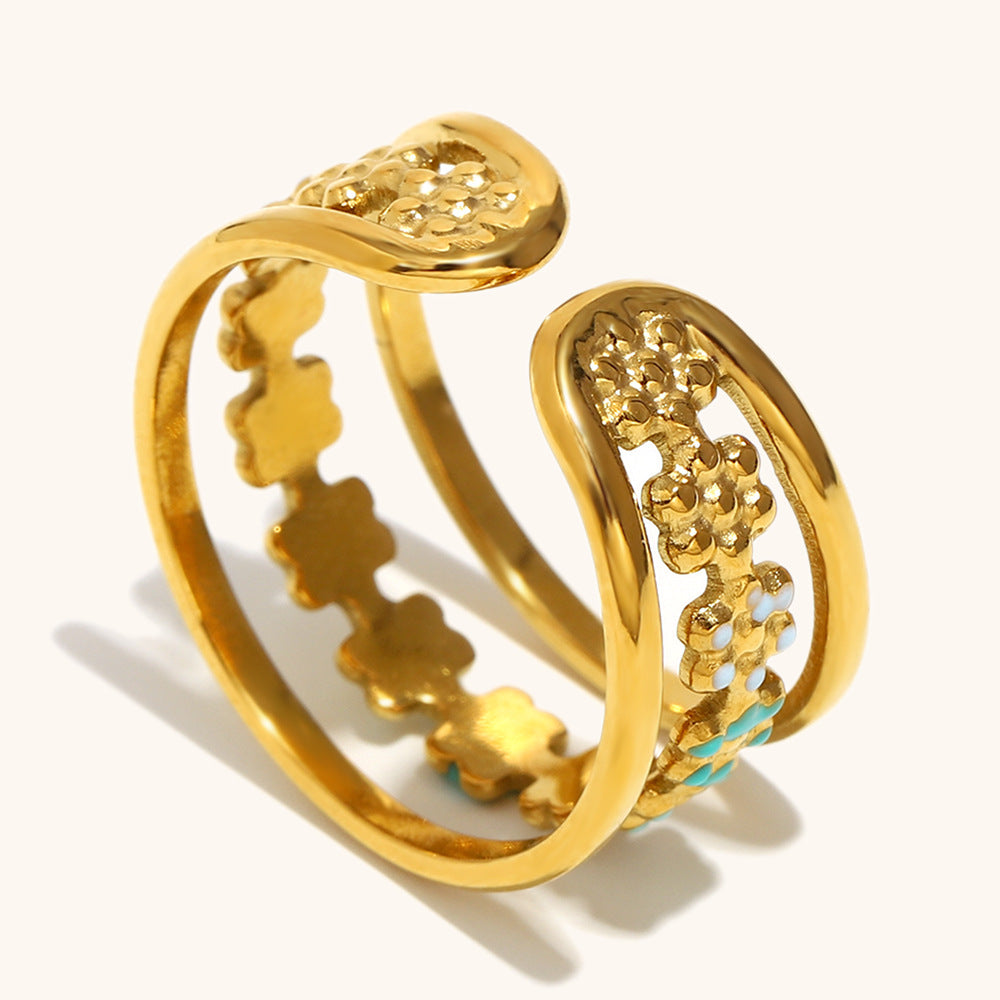 Side view of curved open ring with intricate enamel flower accents.