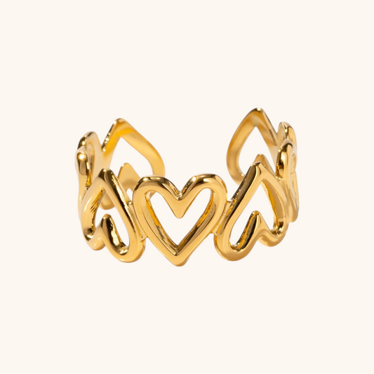 Curved gold band ring with crystals on white backdrop.