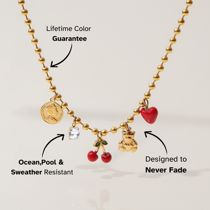 Close-up of red enamel heart and teddy bear charm necklace