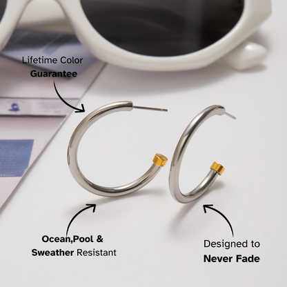 Silver hoop earrings with gold accents on a white surface with text highlighting features.