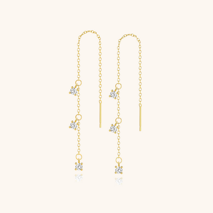 Gold threader earrings with crystal charms displayed on soft cream background