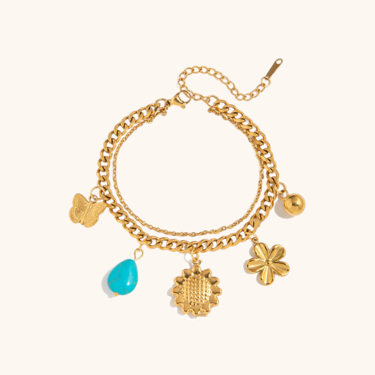 Delicate gold bracelet with flower and butterfly charms styled on a summer outfit
