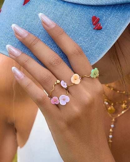 Hand wearing a floral ring with a denim background