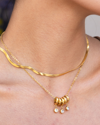 Gold necklace with beads on a person's neck