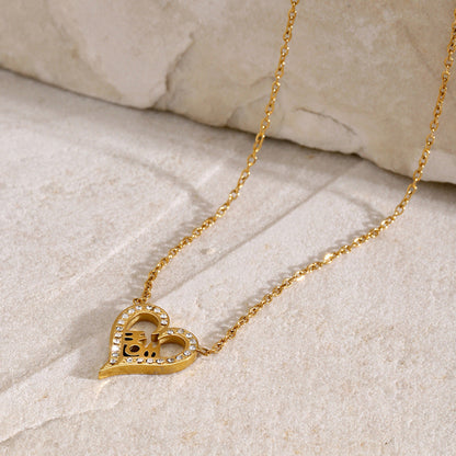 Minimalist MOM necklace with heart charm and crystals, styled on marble stone