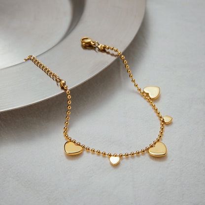 close-up of delicate heart charm bracelet on a white tablecloth