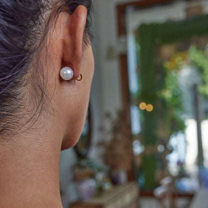 Stylish front-back pearl earrings with crystal accents worn by model