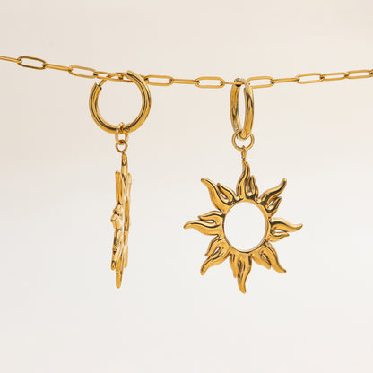 Pair of waterproof gold sun earrings hanging on a chain