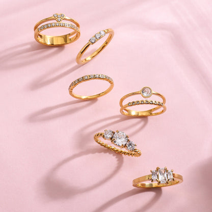 Pink background flatlay of stackable gold rings for daily wear