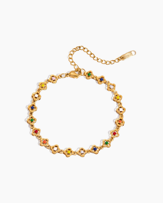 Gold bracelet with colorful gemstones on a white background