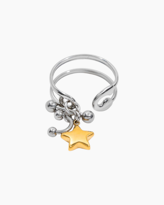 Silver ring with gold star charm on a white background
