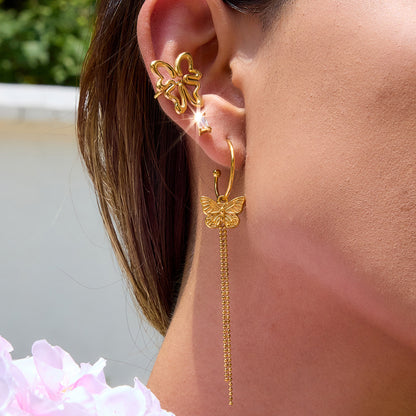 Outdoor shot of woman wearing butterfly drop earrings with floral outfit
