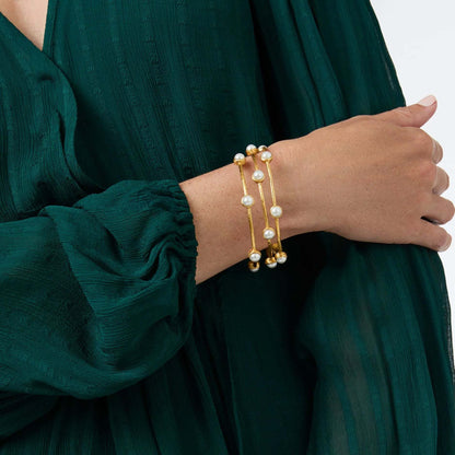 Gold pearl bracelet styled with green outfit