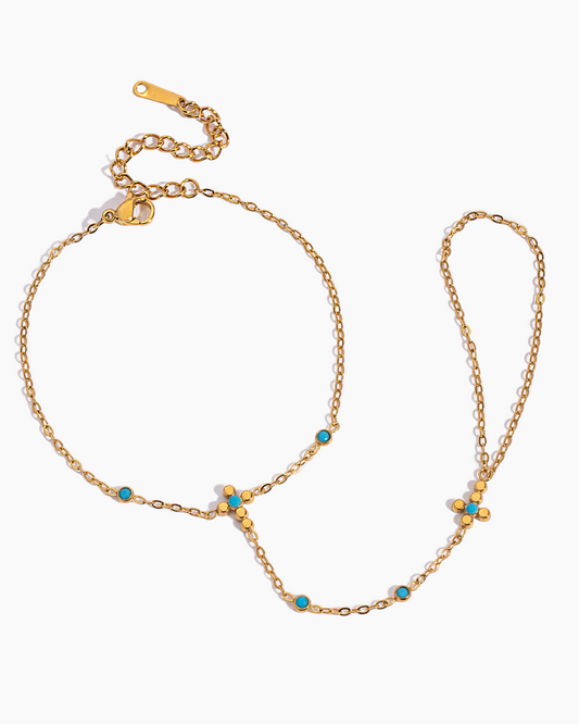 Gold chain necklace with turquoise beads on a white background