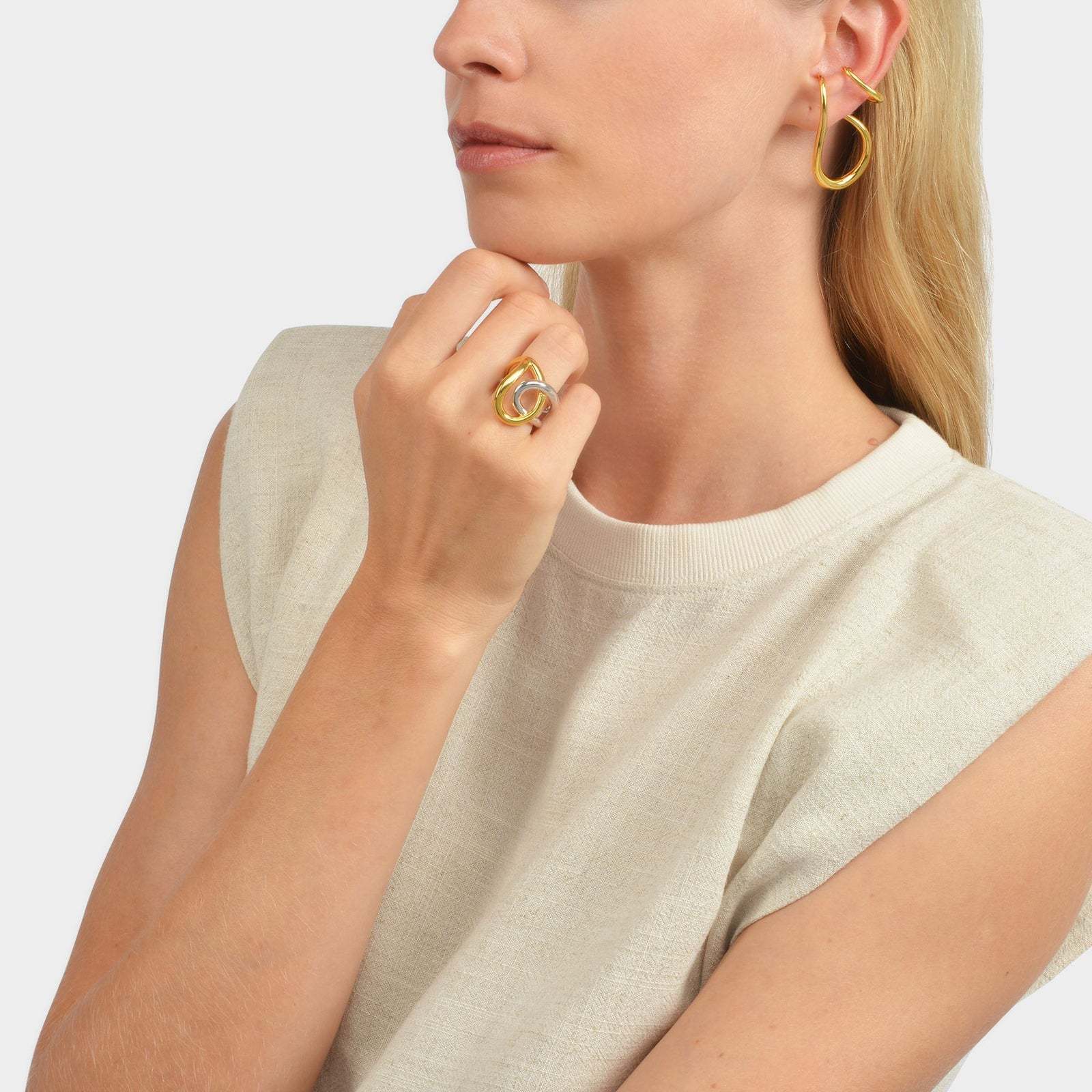 Fashionable woman wearing a silver and gold statement ring with matching earrings