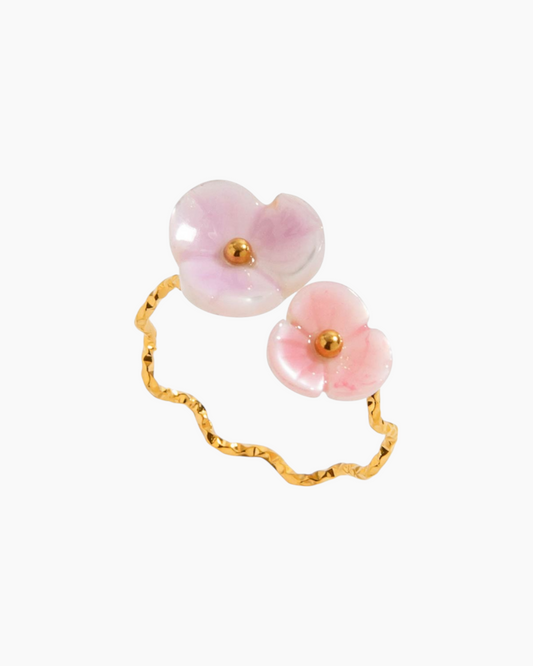 Ring with pink floral stones and gold accents on a white background