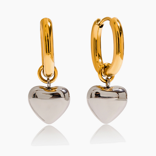 Gold hoop earrings with silver heart pendants on a white background