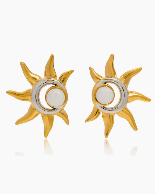Gold sun-shaped earrings with a central white circle on a white background