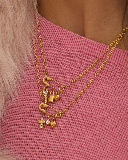 Gold necklaces with charms on a pink sweater