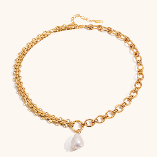 Minimalist white background showcasing asymmetrical gold chain and baroque pearl charm