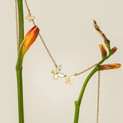 A stylish butterfly necklace with a floating design displayed on a white background.