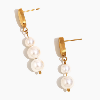 Model wearing elegant pearl drop earrings styled with evening dress