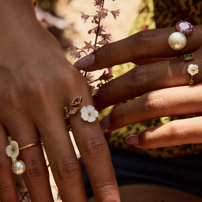 Layered floral rings on hand holding wildflowers outdoors