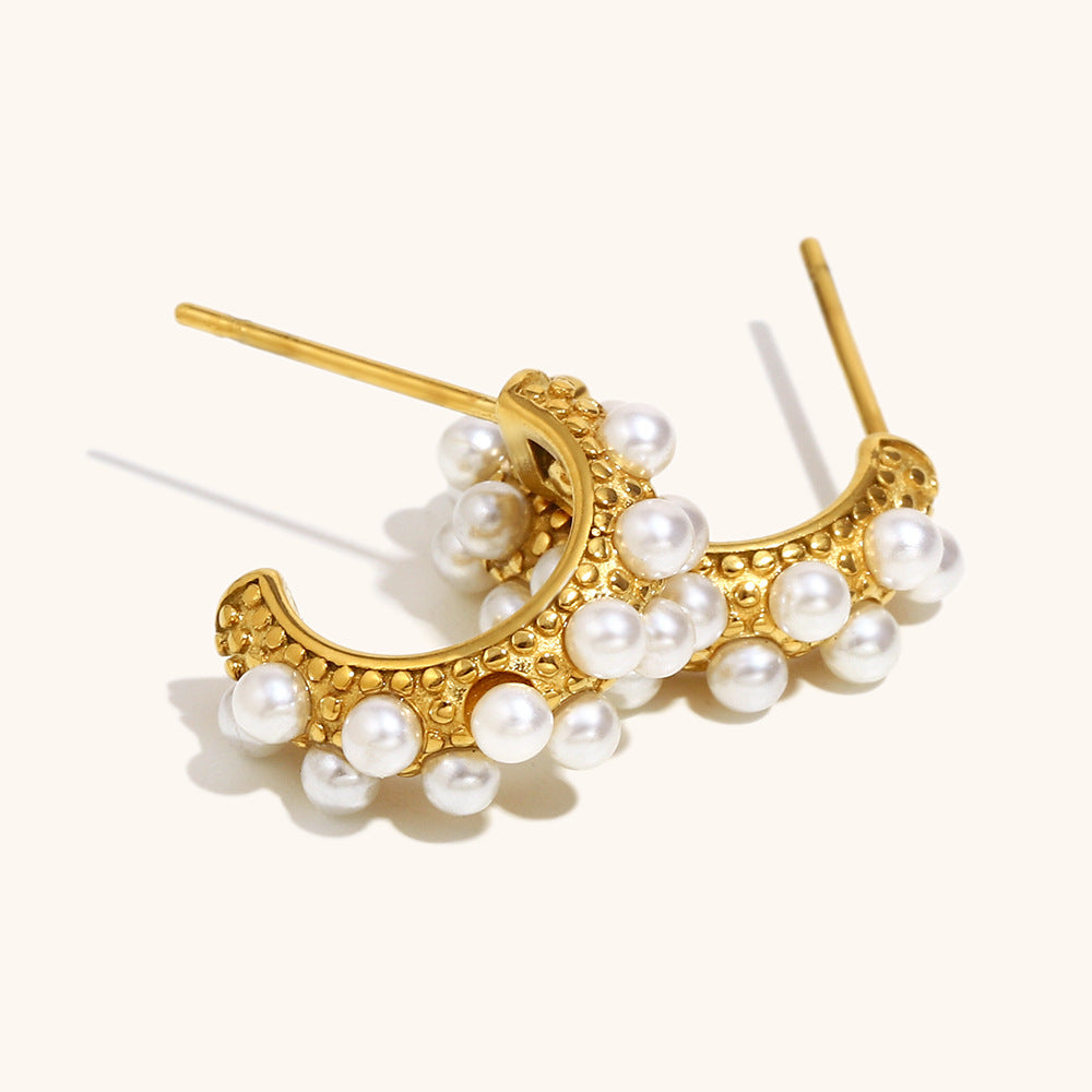 Angled view of mini hoop earrings with raised pearl accents