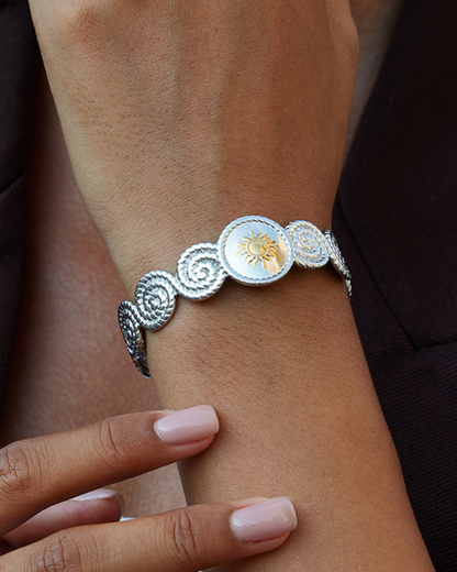Silver bracelet with decorative elements on a wrist