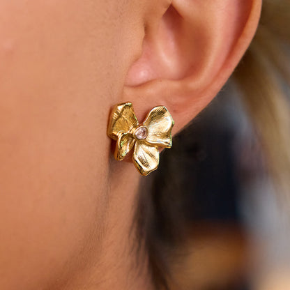 model wearing gold flower studs