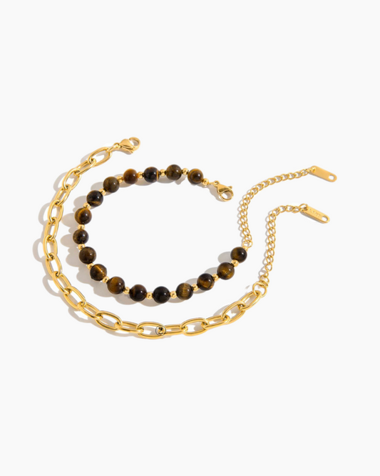 Two necklaces on a white background, one with gold chain and the other with tiger eye beads.