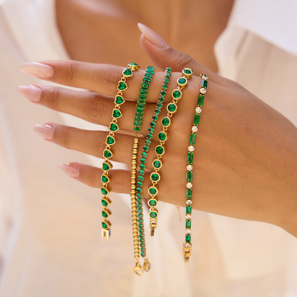 Model hand resting on a straw hat, showing off green crystal bracelet_MiFJewelry