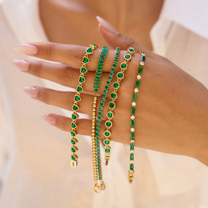 Model hand resting on a straw hat, showing off green crystal bracelet_MiFJewelry