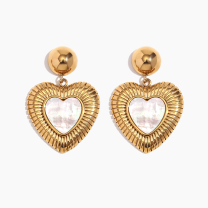 Heart-shaped earrings with gold frames and white centers on a light gray background