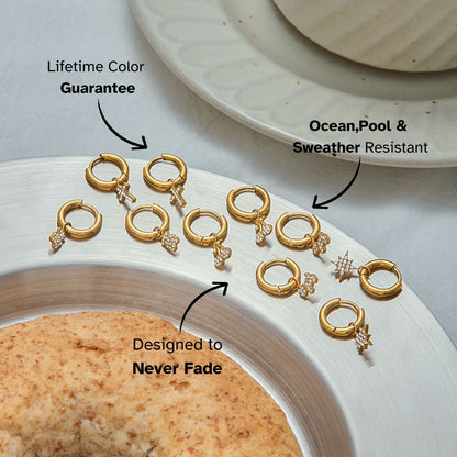 Flat lay of gold huggie earrings with cherry charms styled by a coffee plate_MiFJewelry