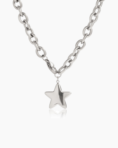 Silver star pendant on a chain against a white background