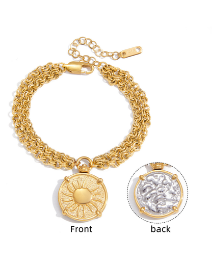 Gold bracelet with a decorative pendant on a white background