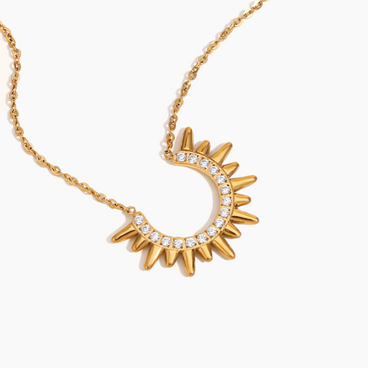 Gold necklace with a sun-shaped pendant on a white background