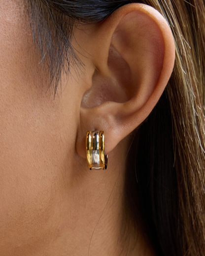 Close-up of an ear wearing a gold hoop earring.