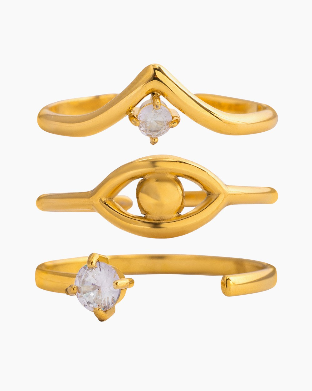 White background photo of a 3-piece gold ring set featuring an evil eye design, V-shaped zircon ring, and open band with crystal.