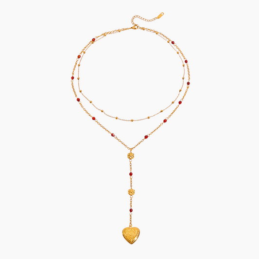 Gold necklace with heart pendant on a white background