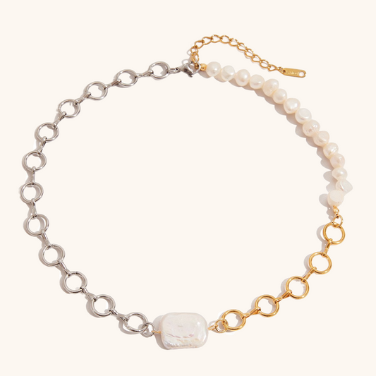 Product image of mixed metal and pearl necklace with asymmetric design on white background
