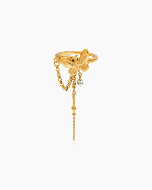 Gold ring with butterfly design and chain on a white background