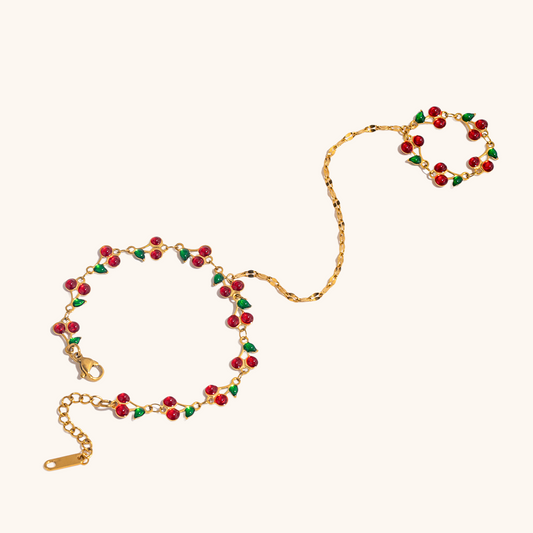 Flat lay of cherry and strawberry inspired bracelets and rings on a neutral background