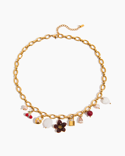 Gold necklace with various charms on a white background